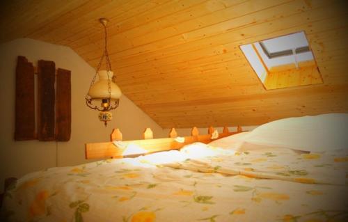 a bedroom with a large bed with a wooden ceiling at Căsuța cu Miez - Treehouse in Vîlsăneşti