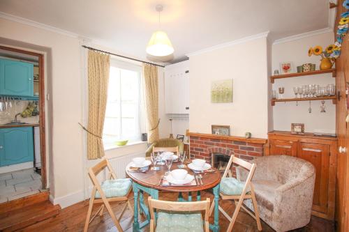 a dining room with a table and chairs at Poppy Cottage in Swanage