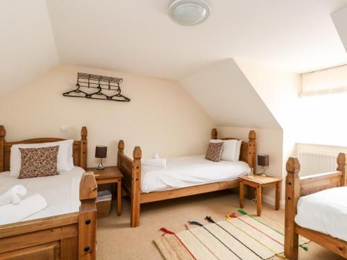 a attic bedroom with two beds and a window at Globe Cottage in Weymouth