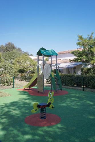 a playground with a slide in a park at Comfort Aparthotel Mandelieu la Napoule Village in Mandelieu-la-Napoule