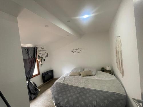 een slaapkamer met een bed in een witte kamer bij Love’Room in Trèbes