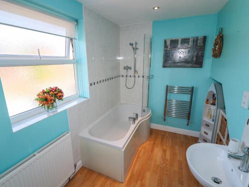 a bathroom with a tub and a sink at Roecliffe in Boroughbridge