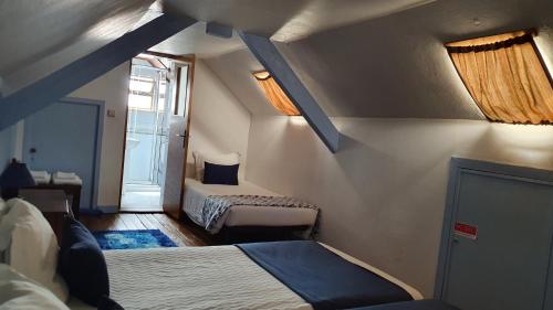 Habitación pequeña con 2 camas y ventana en Hospedaria 5 Bicas, en Aveiro