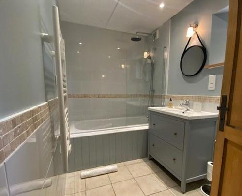 La salle de bains est pourvue d'une douche, d'une baignoire et d'un lavabo. dans l'établissement Granary at Kergudon Gites, à Sizun