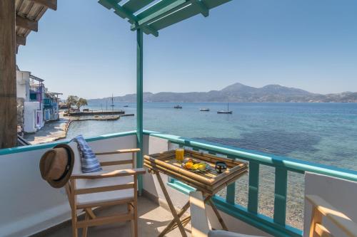 a balcony with a table and chairs on the water at Turquoise Boathouse in Klima II in Klima