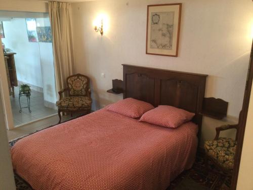 ein Schlafzimmer mit einem Bett mit zwei rosa Kissen in der Unterkunft COMME SUR UN BATEAU FACE À LA MER in Agon Coutainville