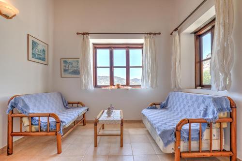 a bedroom with two beds and a table and a window at Sermar Villa in Episkopi Pafou