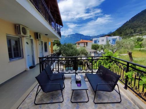a balcony of a house with chairs and a table at Studios Apollon in Chrysi Ammoudia