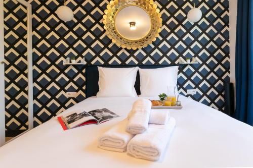 - une chambre avec un lit, des serviettes et un miroir dans l'établissement WS Notre-Dame - Linné, à Paris