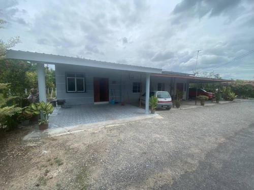 a house with a car parked in front of it at Makndak Roomstay in Arau
