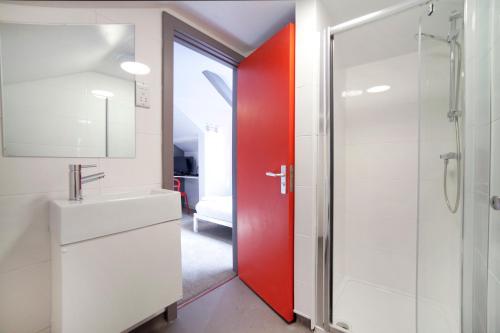 a bathroom with a red door and a sink at Sleeperdorm in Newcastle upon Tyne