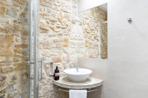 une salle de bain avec un lavabo et un mur en pierre dans l'établissement ART HOME - T2 au coeur de Lyon, à Lyon