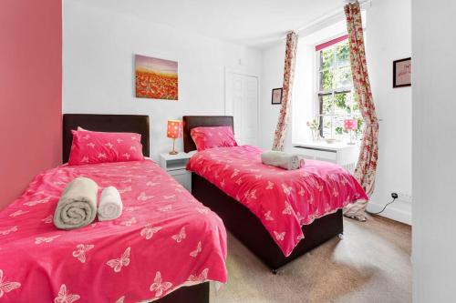 エディンバラにあるSt Marys Streetのベッドルーム1室(ピンクのシーツが備わるベッド2台、窓付)