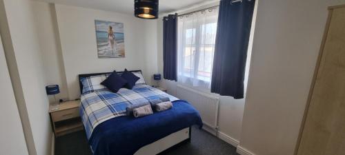 a bedroom with a blue and white bed with a window at Shirely S, Milton, Cambridge, 2BR House, Newly Refurbished in Milton
