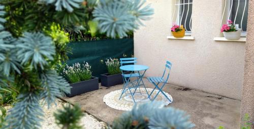two blue chairs and a table and some plants at Fleurs de Cosmos in Albi