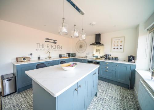 a kitchen with blue cabinets and a white counter top at 'The View' Penthouse Apartment Number Four Lees Terrace in Holt