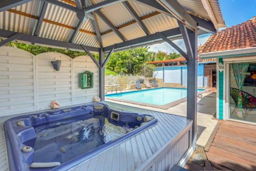 un bain à remous sur une terrasse à côté d'une piscine dans l'établissement Les Villas Créoles de Sainte-Anne, à Sainte-Anne