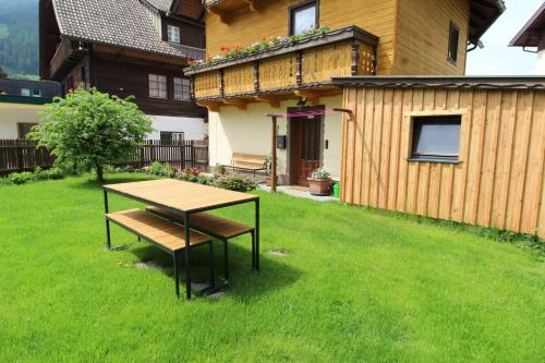 a table and bench in a yard next to a house at CHALET SCHWALBENNEST in Bad Kleinkirchheim