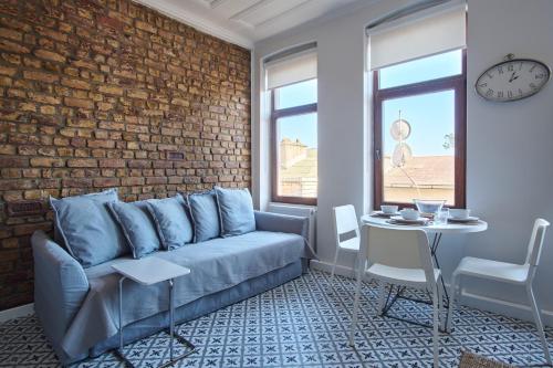 Una sala de estar con un sofá azul y una pared de ladrillos. en Sunflower Apartments, en Estambul