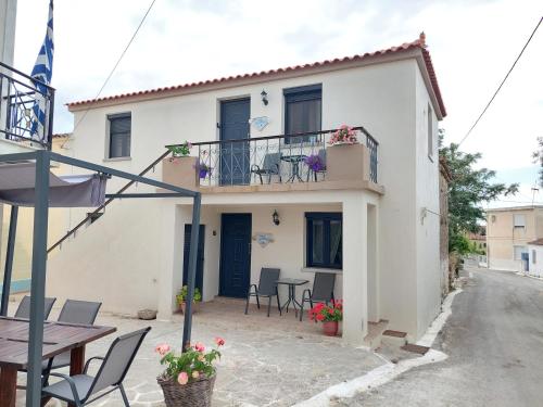 a small white house with a table and chairs at Melissa Keros in Roussopoúlion