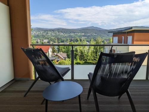 two chairs sitting on a balcony with a view at Vista Bahía, Apartment in Velden with amazing views and lake access in Velden am Wörthersee