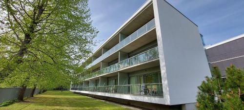 a large white building with trees in front of it at Seedri Breakwater Residence in Pärnu