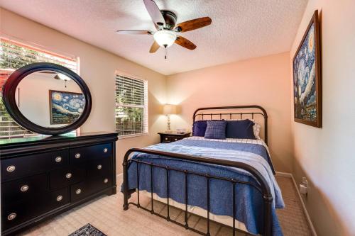 a bedroom with a bed and a mirror and a ceiling fan at Pinwheel Place in Jacksonville