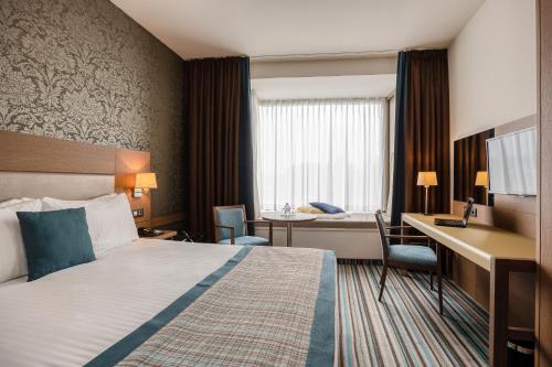 a hotel room with a bed and a desk at Leopold Hotel Oudenaarde in Oudenaarde