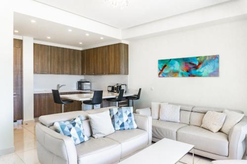 a living room with two couches and a kitchen at Limassol Marina Nereids D22 by Ezoria Villas in Limassol