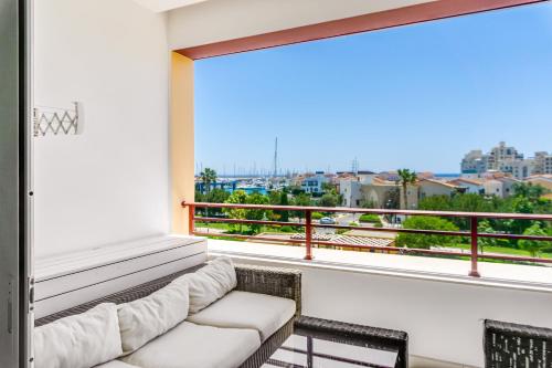 a living room with a couch and a large window at Limassol Marina Nereids D22 by Ezoria Villas in Limassol