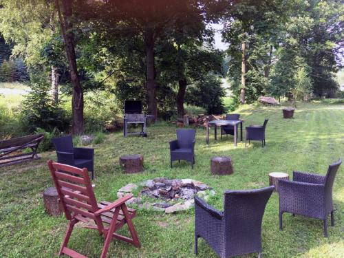 a group of chairs and a fire pit in the grass at CHALUPA NAD POTOKEM in Zlaté Hory