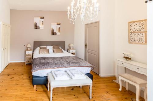 Schlafzimmer mit einem Bett und einem Kronleuchter in der Unterkunft La Voie Du Viaur in Tanus
