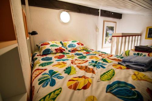 a bedroom with a bed with a colorful bedspread at Appartement Seignosse le Penon/plage in Seignosse