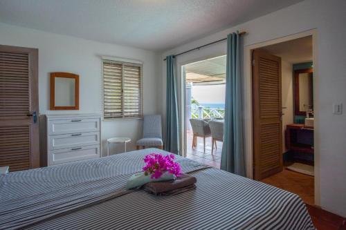 a bedroom with a bed with purple flowers on it at Villa Coral Breeze in Willemstad