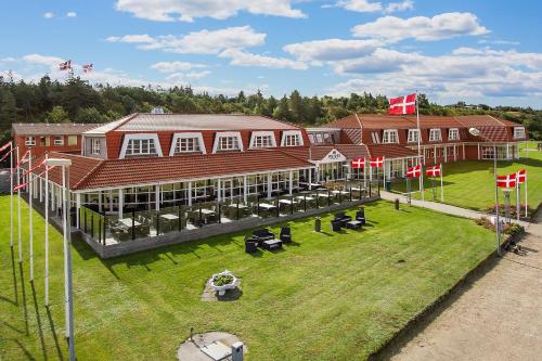 an overhead view of a large building with chairs in the grass at Hotel Pinenhus in Glyngøre