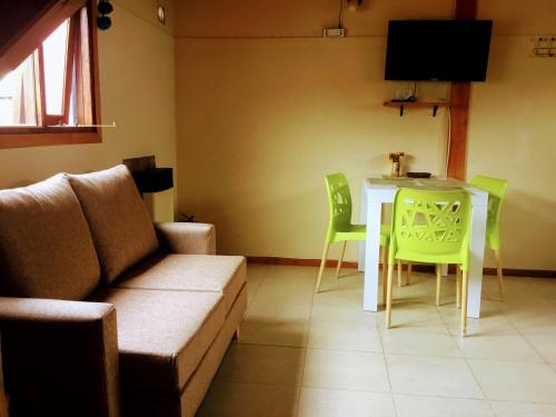een woonkamer met een bank en een tafel en stoelen bij Los Neneos Chalten in El Chalten