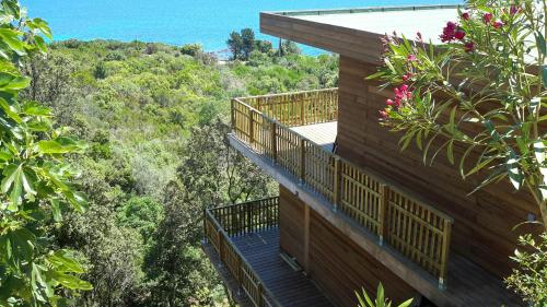a building with a balcony with a view of the forest at Villa l'Alpana en bois vue mer a 180 degres in Sari Solenzara