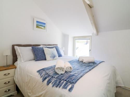 a bedroom with a large white bed with towels on it at Kelmscot in Port Isaac