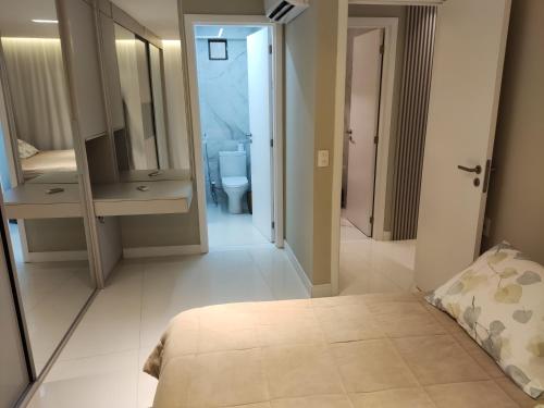 a bedroom with a bathroom with a toilet and a mirror at Flat encantador Slaviero Complexo Heron Marinho in Campina Grande
