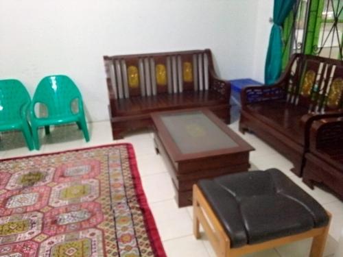 sala de estar con muebles, mesa y sillas en Villa Bukit Asri Untuk 1 Kamar Berastagi View, en Berastagi