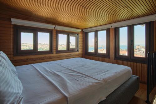 Un dormitorio con una cama en una habitación con ventanas. en Sunflower Apartments, en Estambul