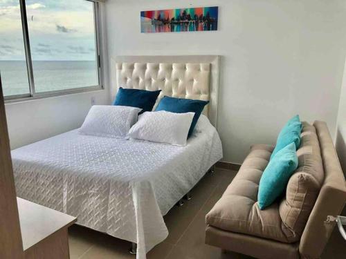una camera con un grande letto e un divano di apartamento en bocagrande a Cartagena de Indias