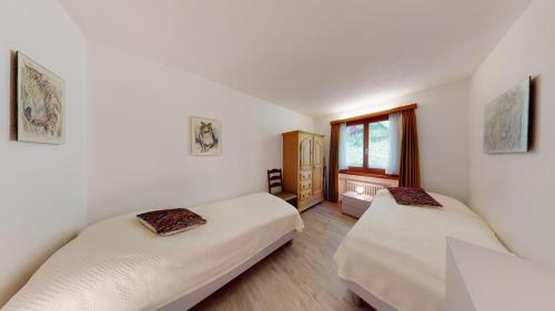 Pokój z 2 łóżkami i oknem w obiekcie Funtauna B38 w Sankt Moritz
