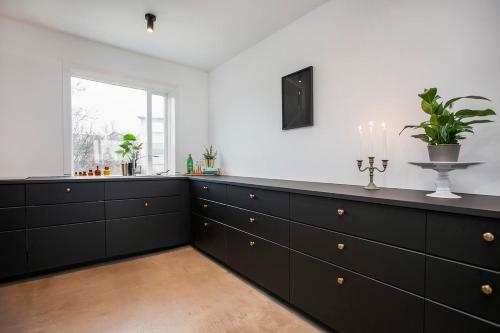 a kitchen with black cabinets and a window at Luxury Apartment In Prime Location Ocean View in Reykjavík