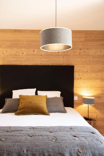 une chambre avec un grand lit avec une tête de lit noire dans l'établissement TERRESENS - L'ETENDARD, à Vaujany
