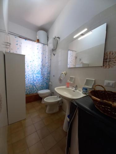 a bathroom with a sink and a toilet and a mirror at Villetta indipendente - Torre dell' Orso in Torre dell'Orso