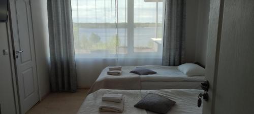 een hotelkamer met 2 bedden en een raam bij Vijuandra in Zarasai