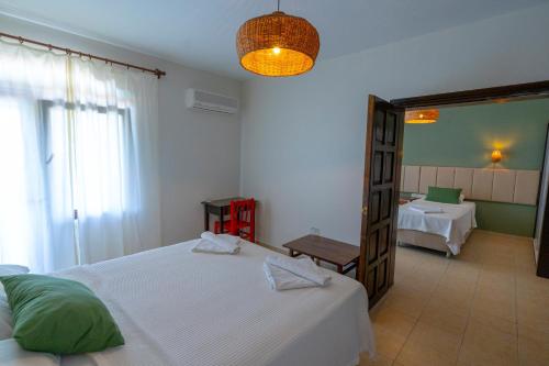 a bedroom with a white bed and a mirror at Xanthos Boutique Hotel Patara in Patara