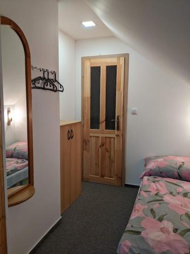 a bedroom with a bed and a mirror and a door at Chalupa u rybníka Střehom in Dolní Bousov