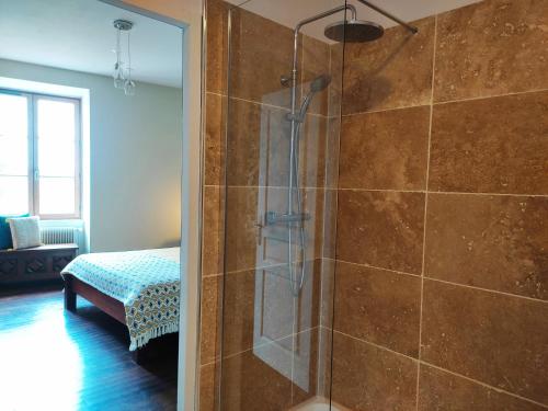 a bathroom with a shower with a glass door at Planches et Plonk in Belvès